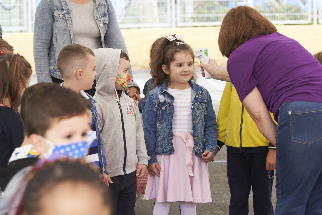 Una niña es sometida a un control de temperatura durante su primer día de vuelta a clase, en una imagen de archivo