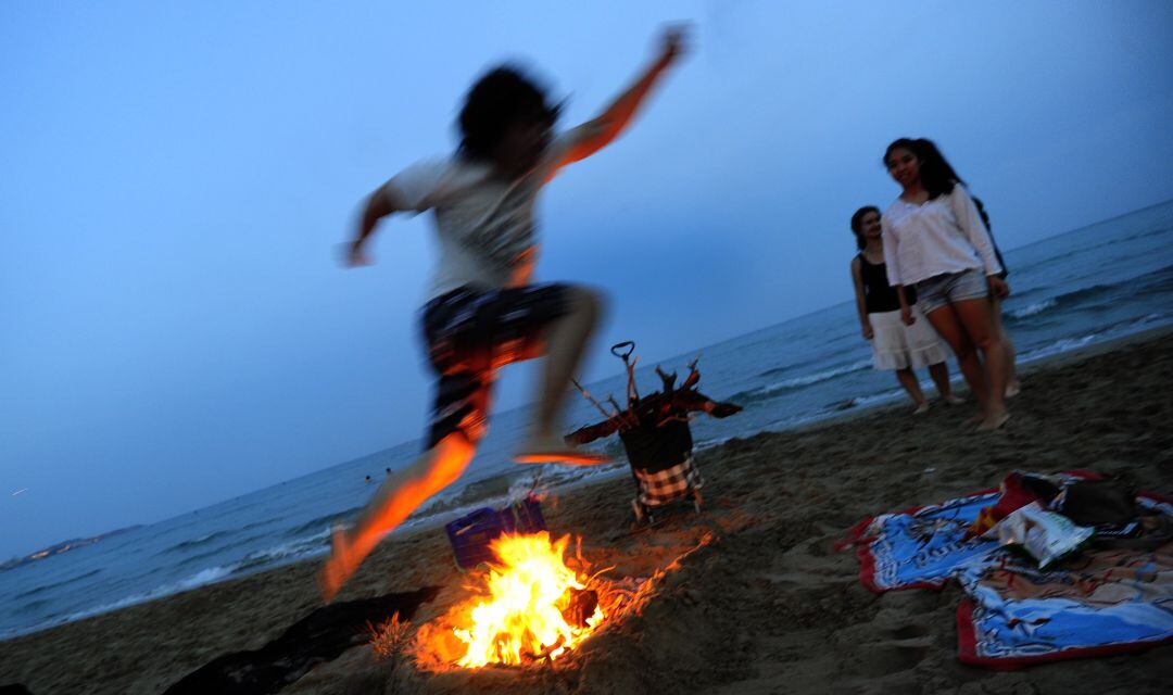 Foto de archivo saltando una hoguera en una playa en la Comunitat Valenciana