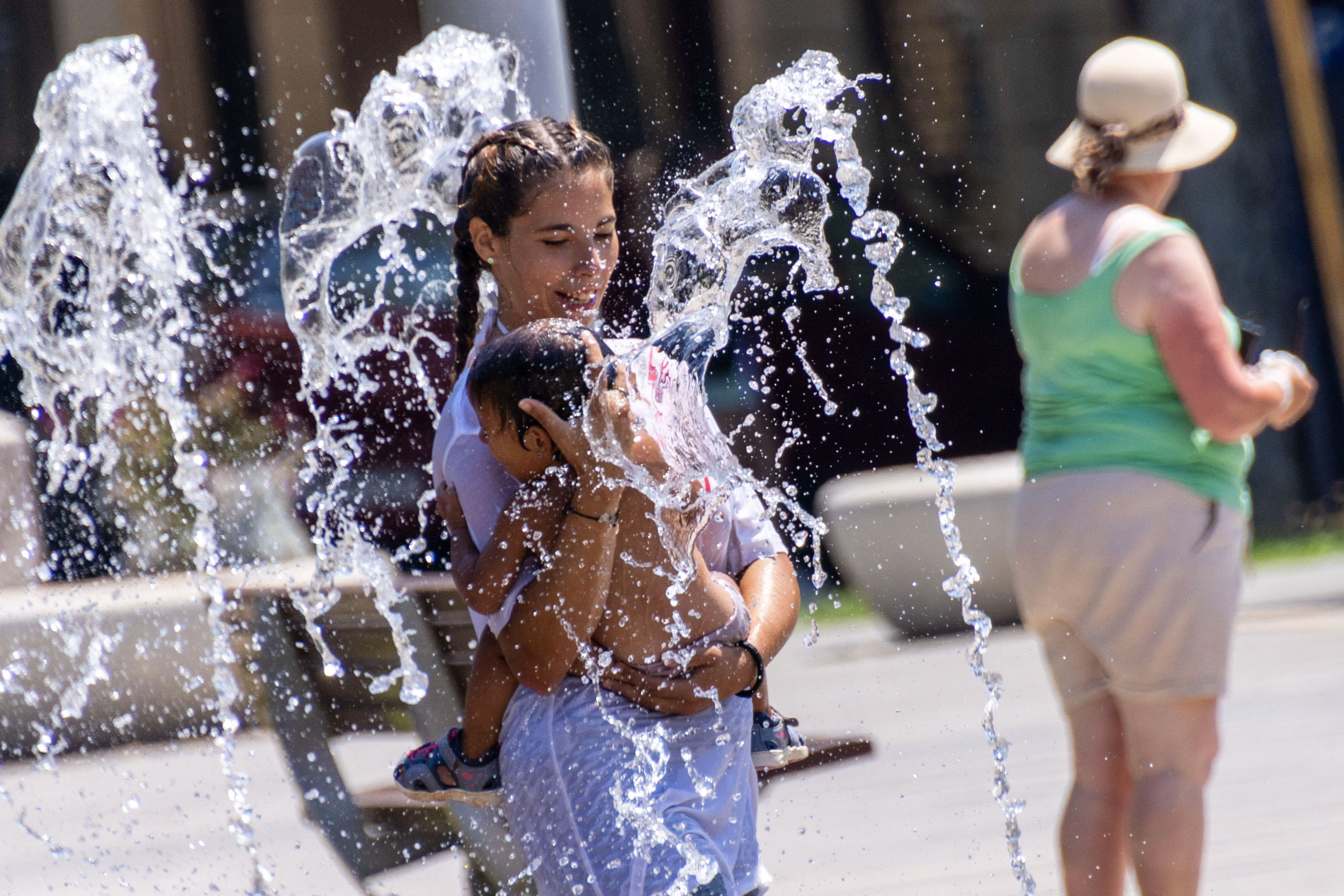 Unos niños se refrescan con los chorros de la escultura acuática del Parque de las Estaciones para combatir el calor este lunes, en Palma de Mallorca.