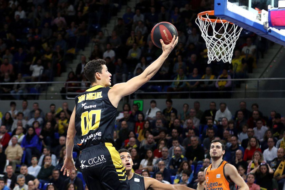 El base del Iberostar Tenerife Rodrigo San Miguel (i) entra a canasta en el partido ante el Valencia Basket de la novena jornada de la Liga Endesa. E