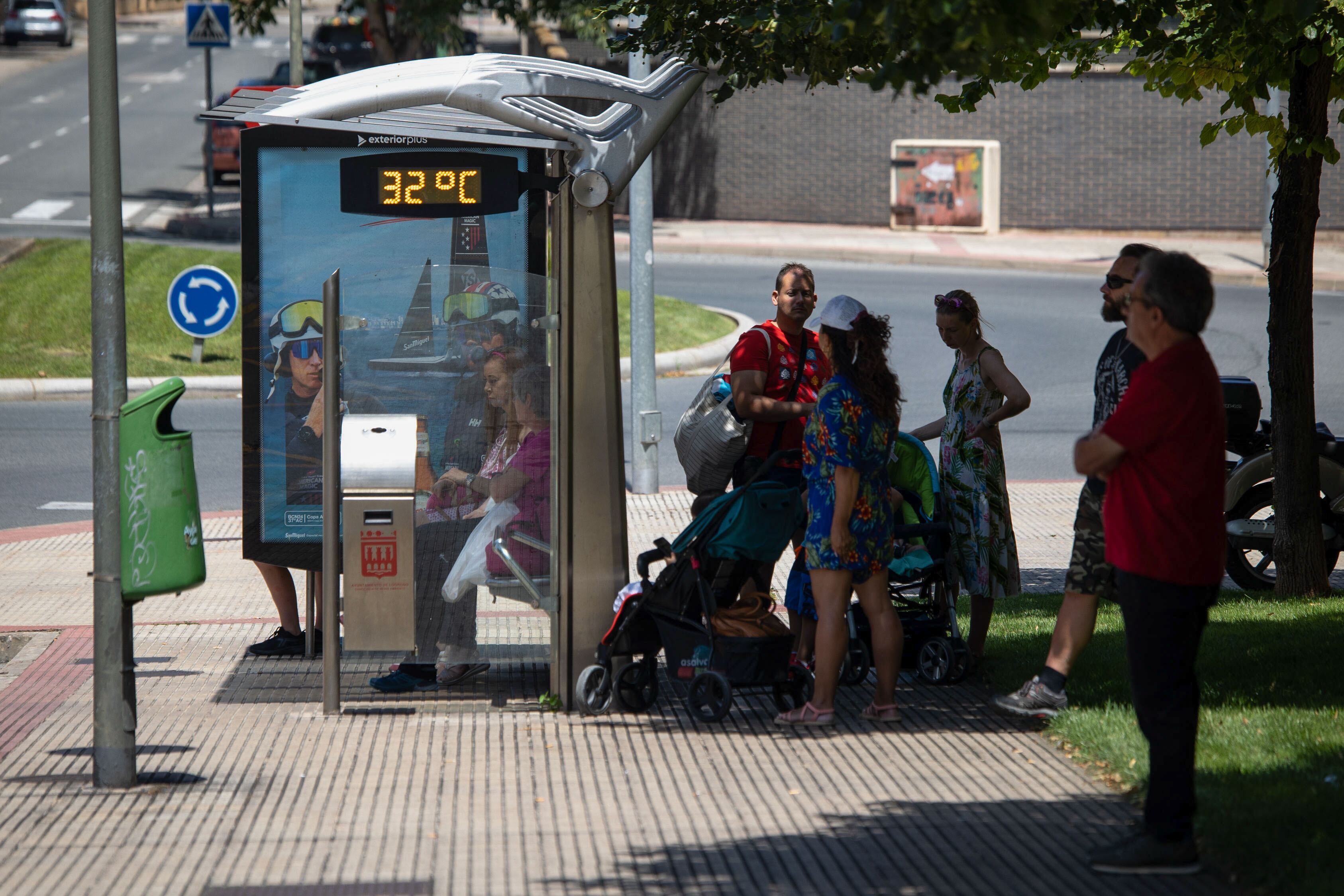 LOGROÑO, 18/07/2024. Un grupo de personas espera la llegada del autobús cobijados bajo una sombra en Logroño, donde este jueves se prevé llegar a un máximo de 38 o 39 grados. El agua y la sombra se convierten estos días en los dos bienes más preciados para aquellos que tienen que trabajar al aire libre en jornadas calurosas como las de hoy. EFE/ Raquel Manzanares