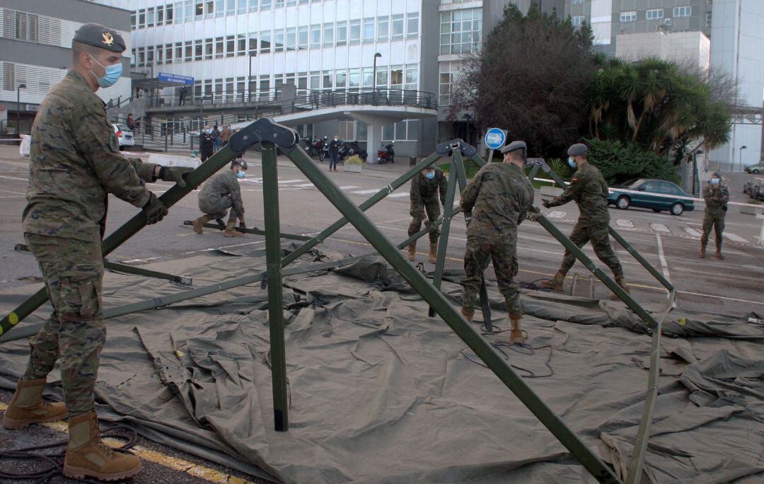 Soldados del Regimiento Príncipe de Asturias montan un hospital de campaña para el triaje de pacientes con covid-19 en la zona de aparcamiento del Hospital de Cabueñes, este viernes, en Gijón.