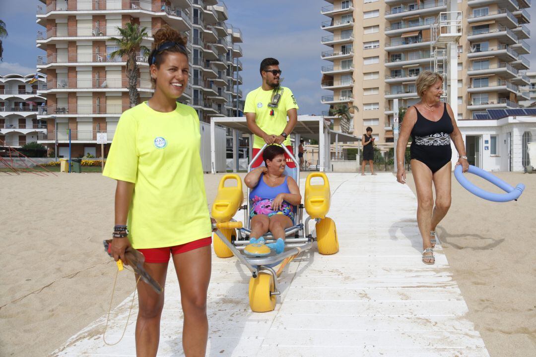 Imatge d'arxiu de dos socorristes ajudant a una usuària amb mobilitat reduïda
