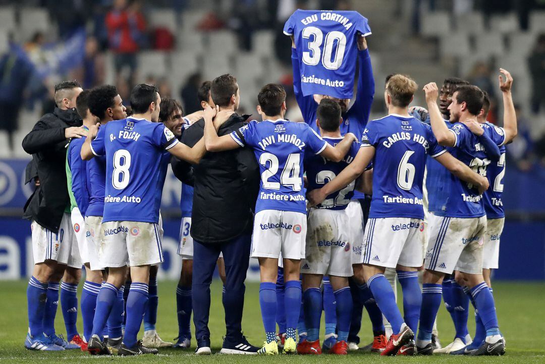 Los jugadores del Oviedo brindan el triunfo a Edu Cortina.