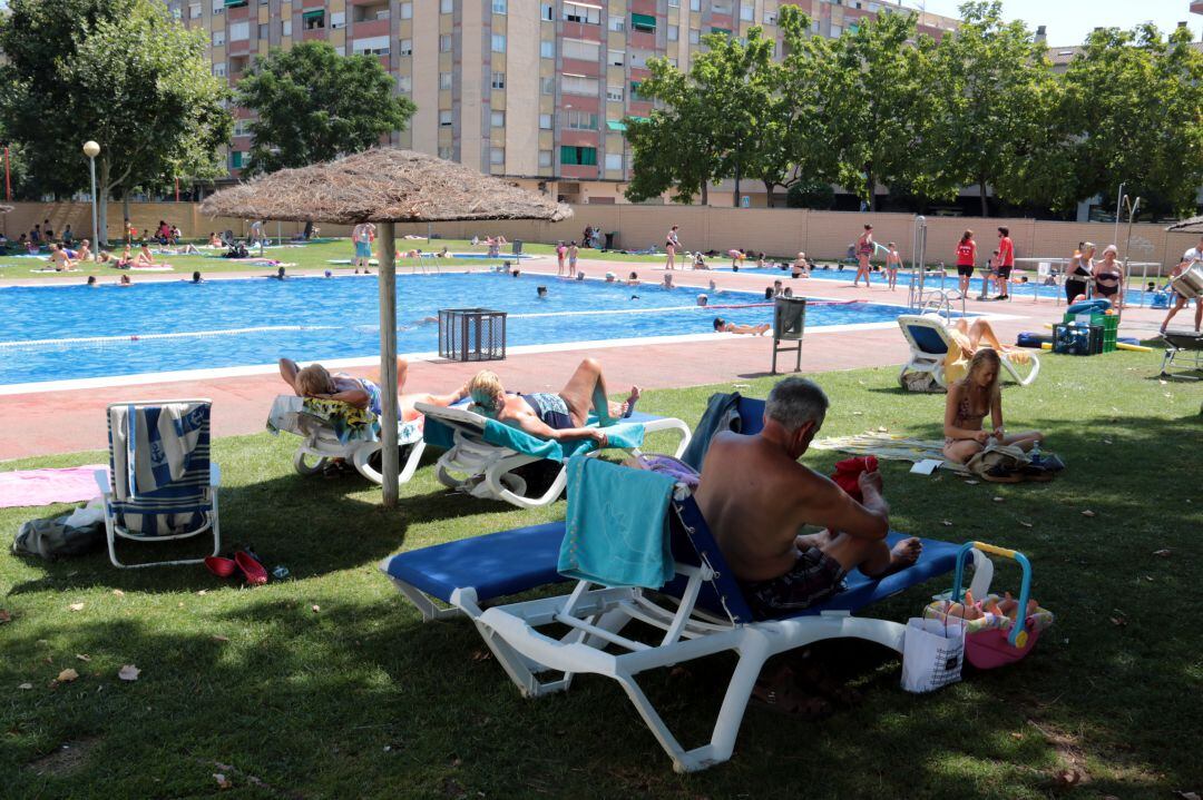 Els dermatòlegs recomanen no prendre el sol i buscar l'ombra, com fan aquests banyistes d'una piscina municipal de Lleida, en una foto d'arxiu.