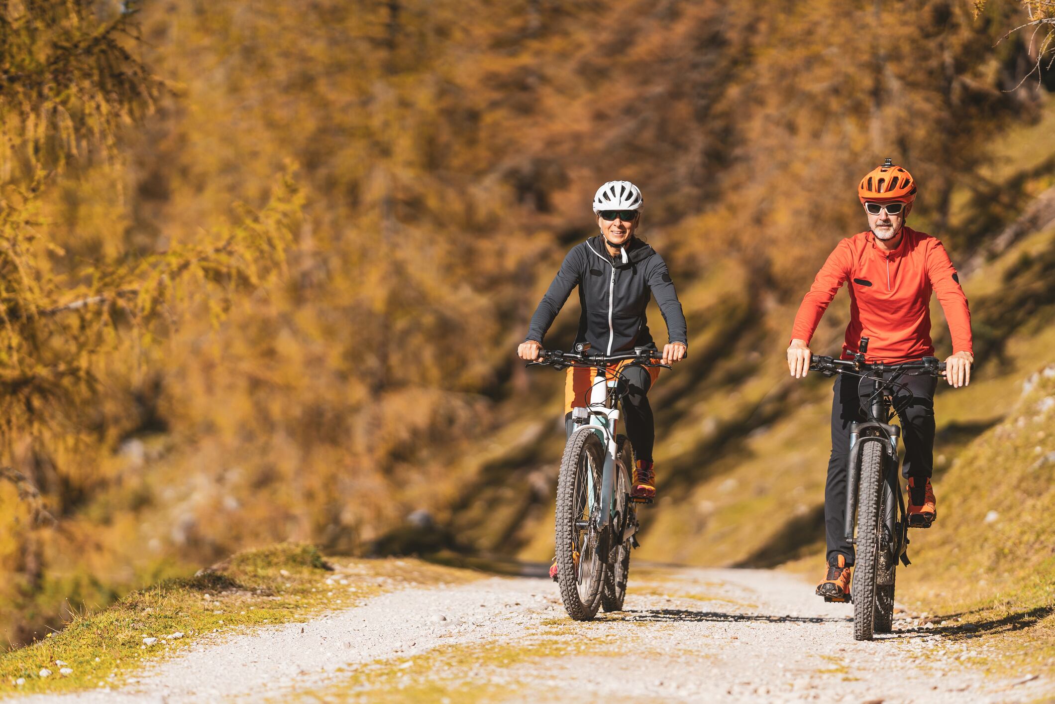 Una pareja ciclista circula por una pista forestal