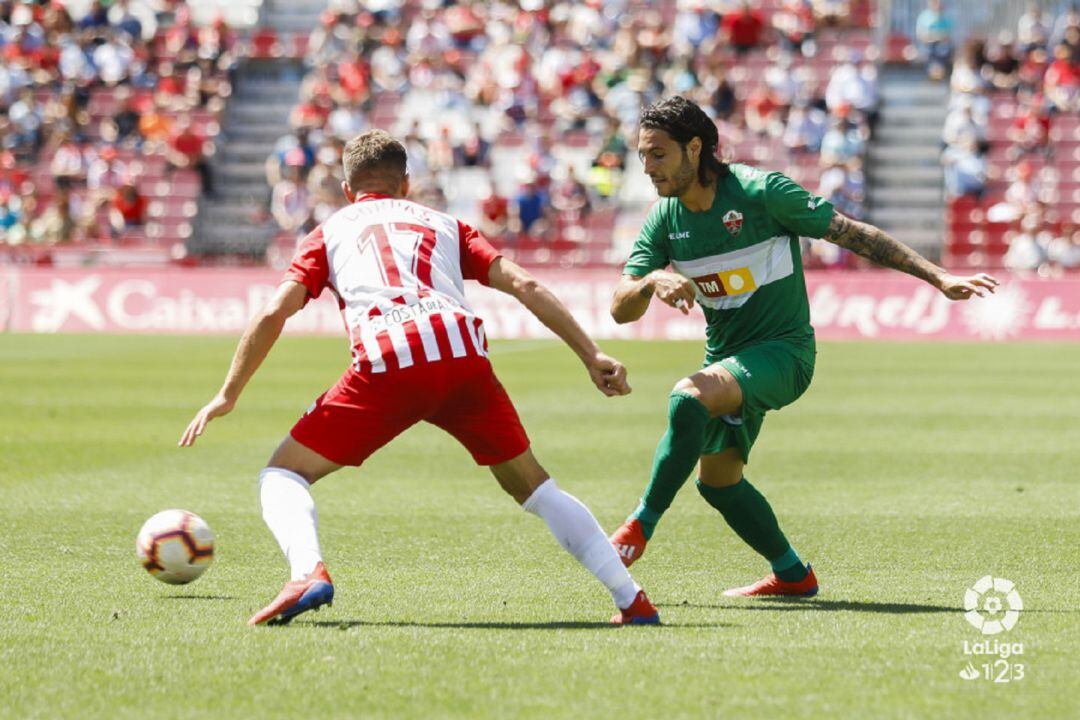 El jugador del Almería Corpas intenta frenar el avance del lateral del Elche Juan Cruz