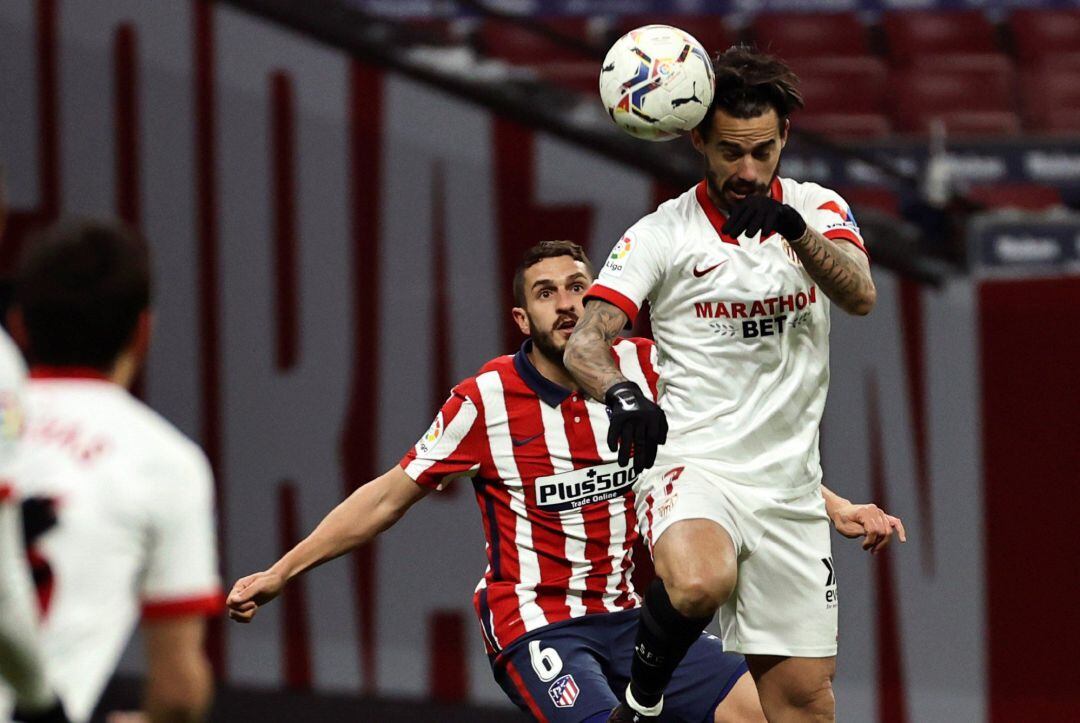 El delantero del Sevilla FC Suso cabecea delante de Koke Resurrección.