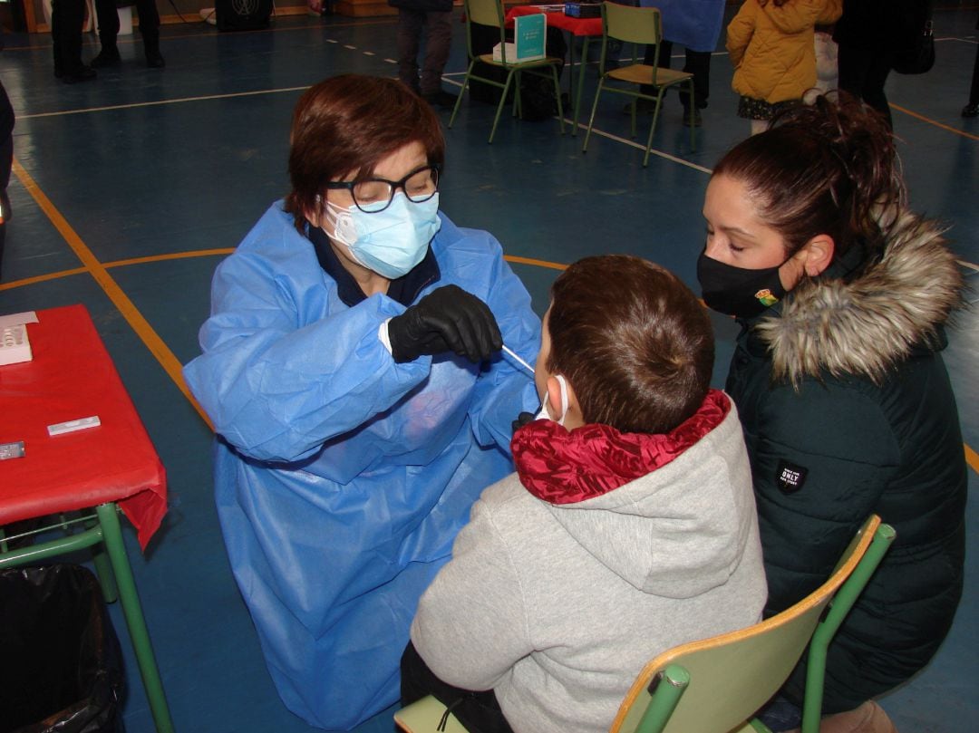 Decenas de familias están pasando este domingo por el pabellón del colegio El Poeta de Serranillos del Valle para someter a sus hijos a los polémicos test de saliva para detectar el coronavirus, con que el consistorio está cribando a su población.