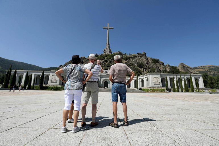 Varios visitantes fotografían el monumento del Valle de los Caídos.