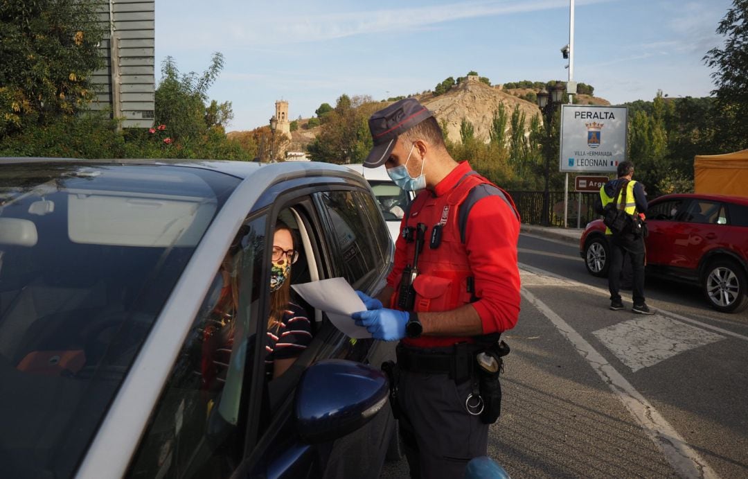 Un agente de la Policía Foral controla una salida de Peralta en el día en que entra en vigor el cierre perimetral de la localidad ante el incremento de casos de Covid-19.