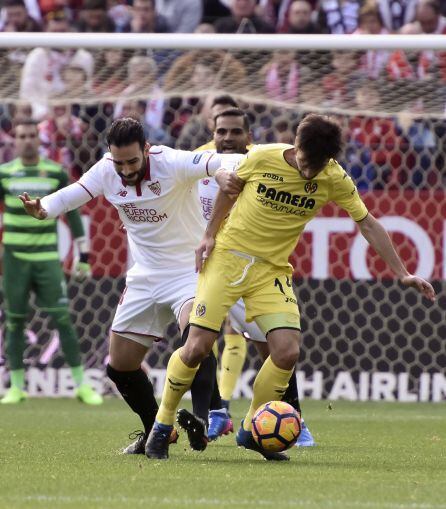 El defensa francés del Sevilla FC Adil Ramí disputa un balón con el centrocampista del Villarreal Manu Trigueros.