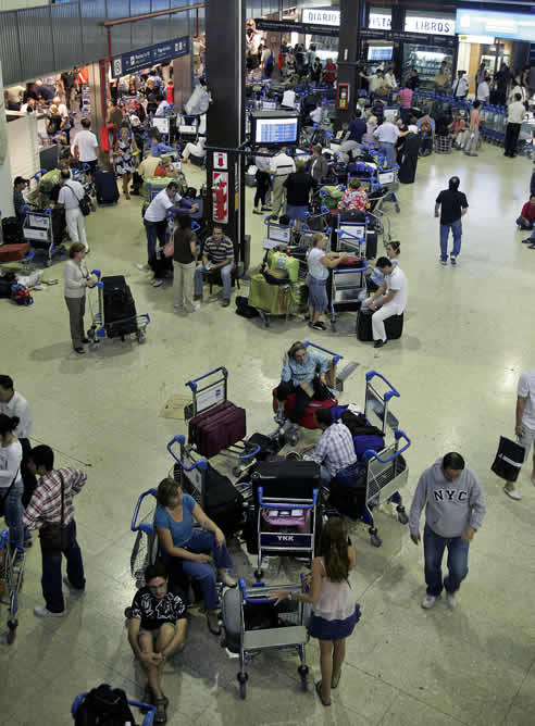 Pasajeros esperan en el hall del Aeropuerto Internacional de Ezeiza la salida de su vuelo en el tercer día de huelga