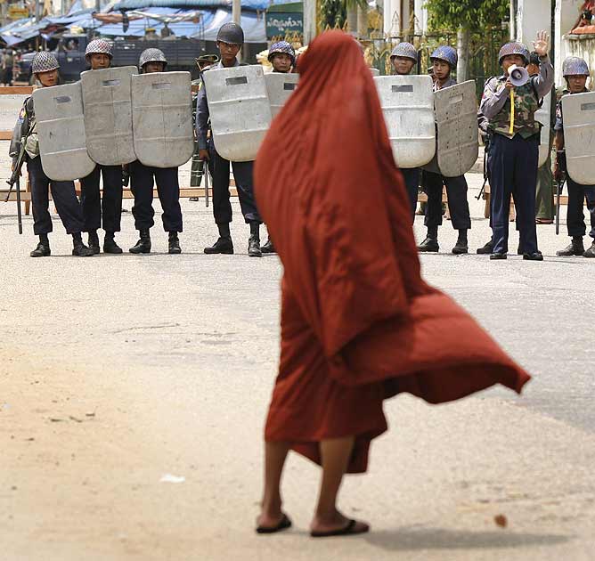 Policías impiden el paso a un monje a la pagoda de Shwedagon.