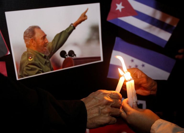 People place candles beside a picture of Fidel, as part of a tribute, following the announcement of the death of Cuban revolutionary leader Fidel Castro, in Tegucigalpa, Honduras November 26, 2016.