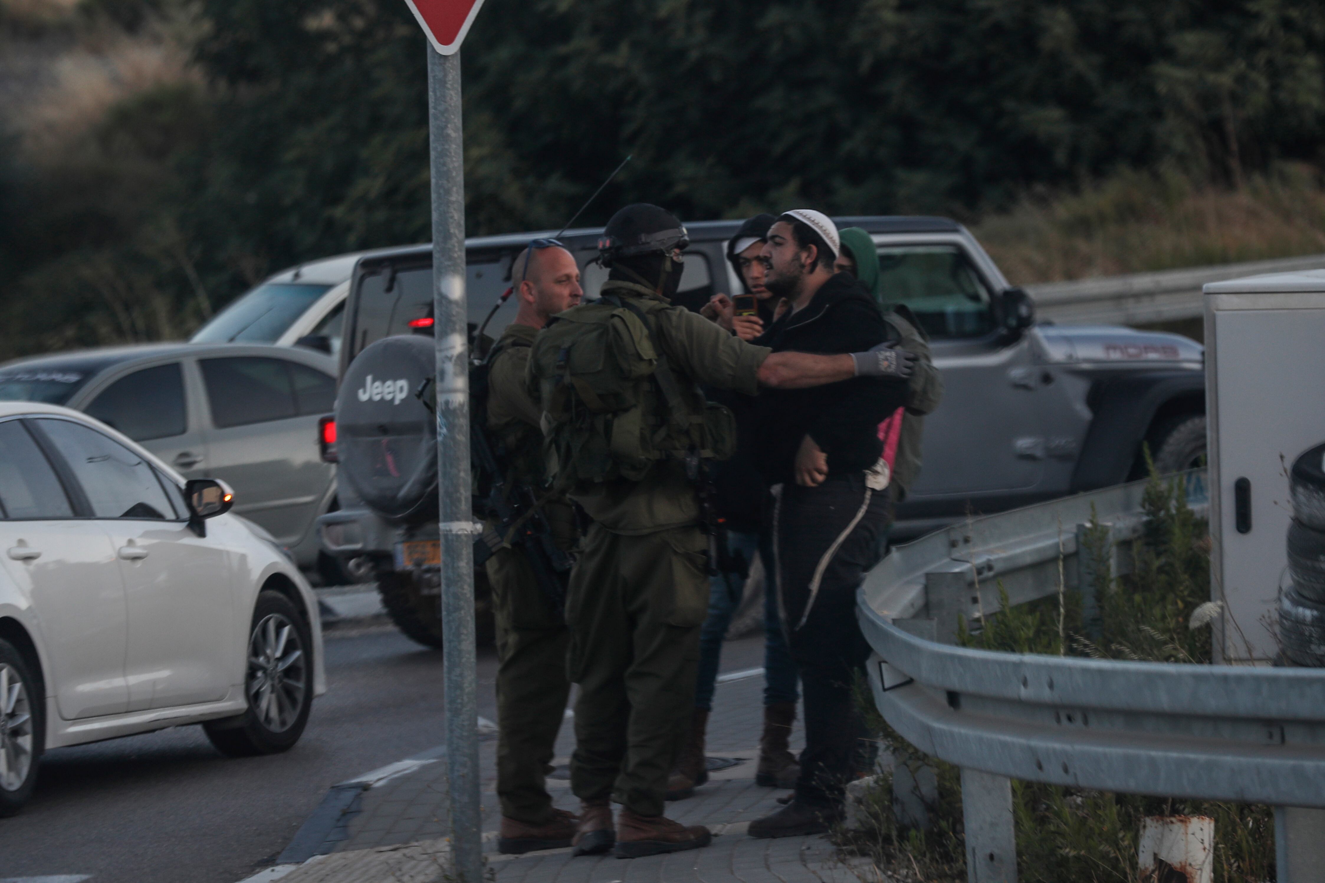 West Bank (---), 20/06/2023.- Israeli soldiers prevent Israeli settlers from attacking a Palestinian car on a road leading to the West Bank city of Ramallah, following the shooting in the settlement of Eli, between Nablus and Ramallah, in the West Bank, 20 June 2023. Four people were killed and one was injured in a shooting at a gas station at the entrance of the Eli settlement, Israeli Defense Forces (IDF) reported. Israeli Army is searching the perpatrators of the shooting and has set up road blockades. (Atentado) EFE/EPA/ATEF SAFADI