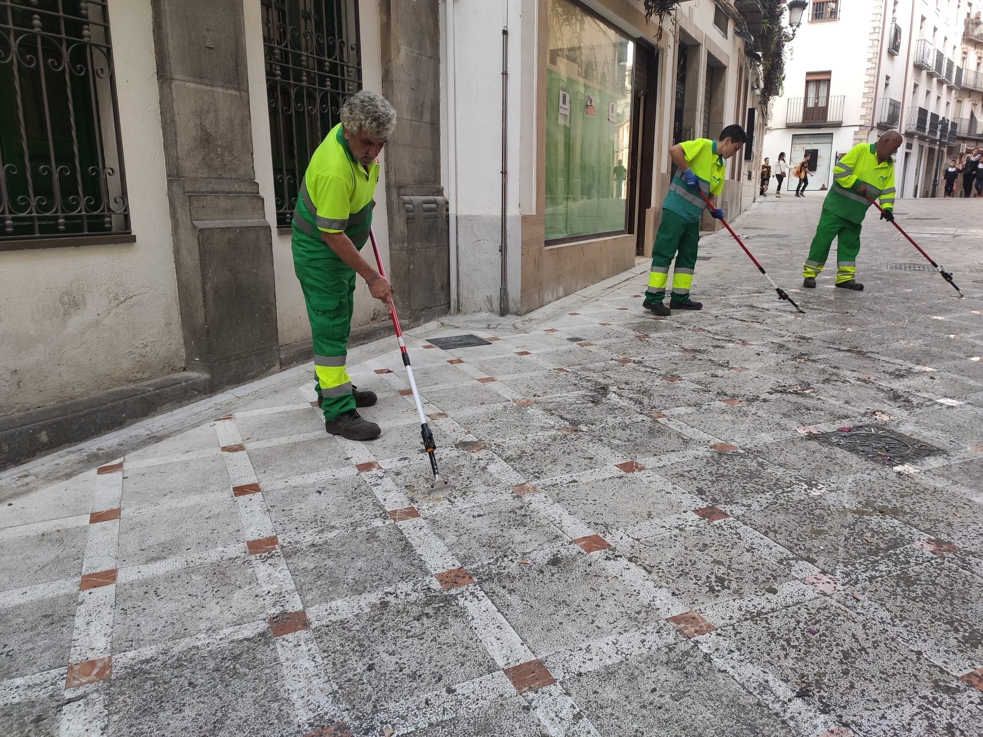 Operarios de FCC realizan labores para retirar la cera de las procesiones en la calle Maestra de Jaén