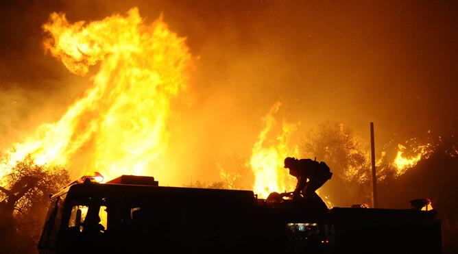 Un camión de bomberos trata de controlar las llamas de uno de los incendios declarado en el norte de la ciudad de Los Ángeles