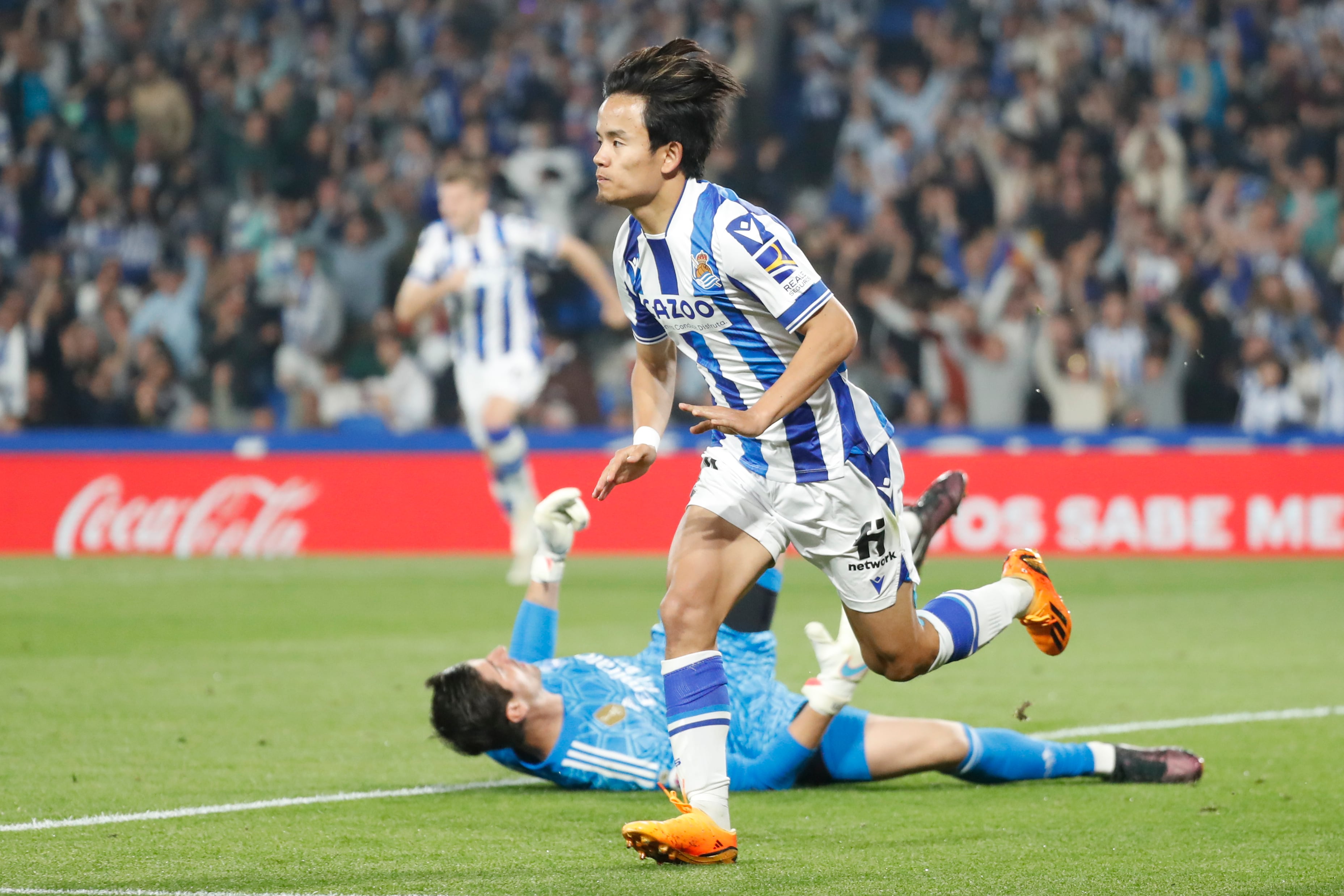 SAN SEBASTIÁN, 02/05/2023.- El centrocampista japonés de la Real Sociedad, Takefusa Kubo, tras batir al guardameta belga del Real Madrid, Thibaut Courtois, durante el encuentro correspondiente a la jornada 33 que disputan hoy martes en el Reale Arena, en San Sebastián. EFE / Juan Herrero.
