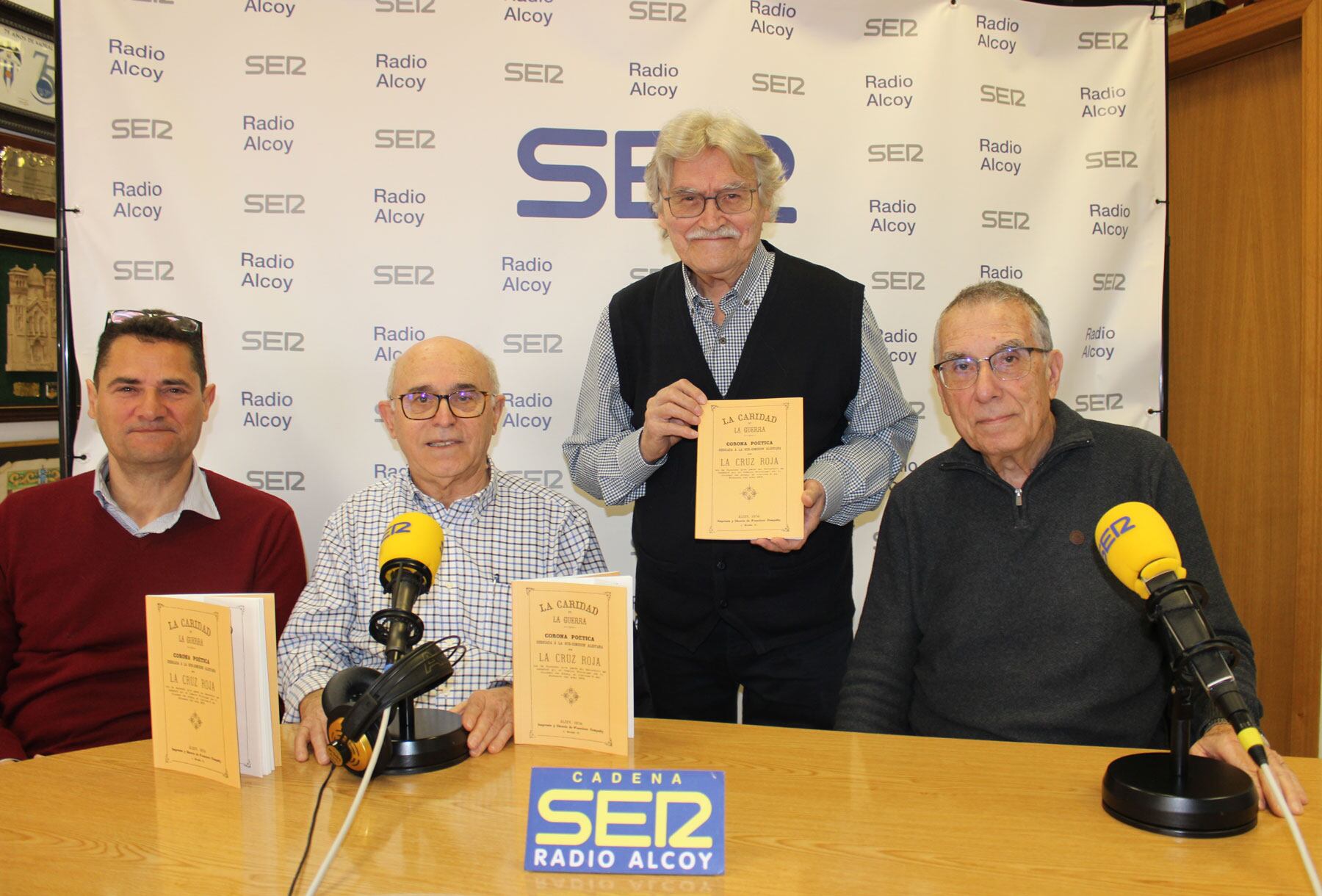 Pablo Granados, Paco Blay, Luis Llorens i Àngel Beneito, en l'estudi central de Radio Alcoy, amb exemplars d'aquesta publicació