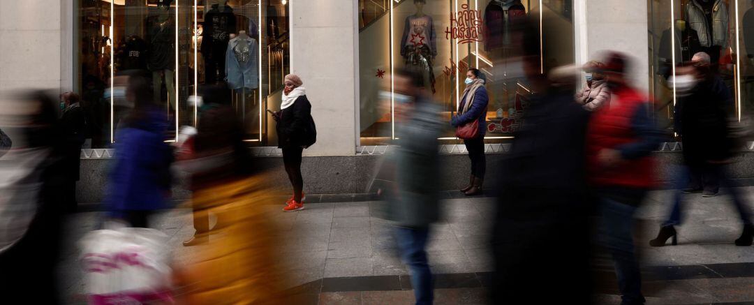 Viandantes pasean por el centro de Madrid, este lunes. Las restricciones y el parón económico originados por la pandemia de coronavirus pueden hacer que las de enero de 2021 sean las peores rebajas de la historia, superando incluso la campaña de 2013, cuando las ventas se redujeron un 25 %, según datos de la Confederación Española del Comercio (CEC). 