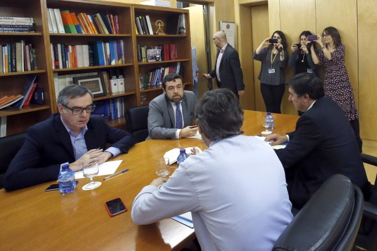 El portavoz parlamentario del PP, Rafael Hernando (2d, de espaldas), junto al diputado José María Bermúdez de Castro (d), y el portavoz de Ciudadanos, Juan Carlos Girauta (i), con el secretario general del grupo, Manuel Gutiérrez (2i), durante la reunión 