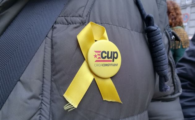 Chapa de la CUP en el abrigo de un manifestante frente al Supremo