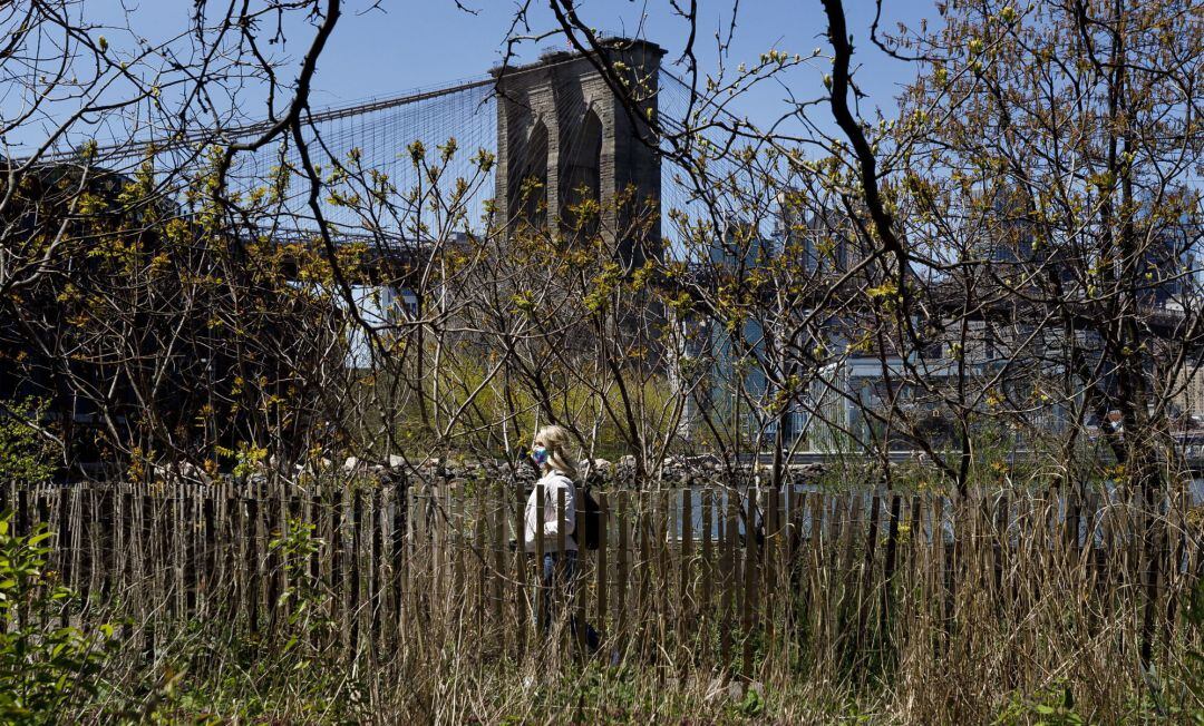 Una mujer pasea cerca del puente de Brooklyn en Nueva York