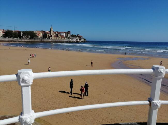 Agentes de la Policía Nacional informan este martes a una usuaria de la playa de San Lorenzo
