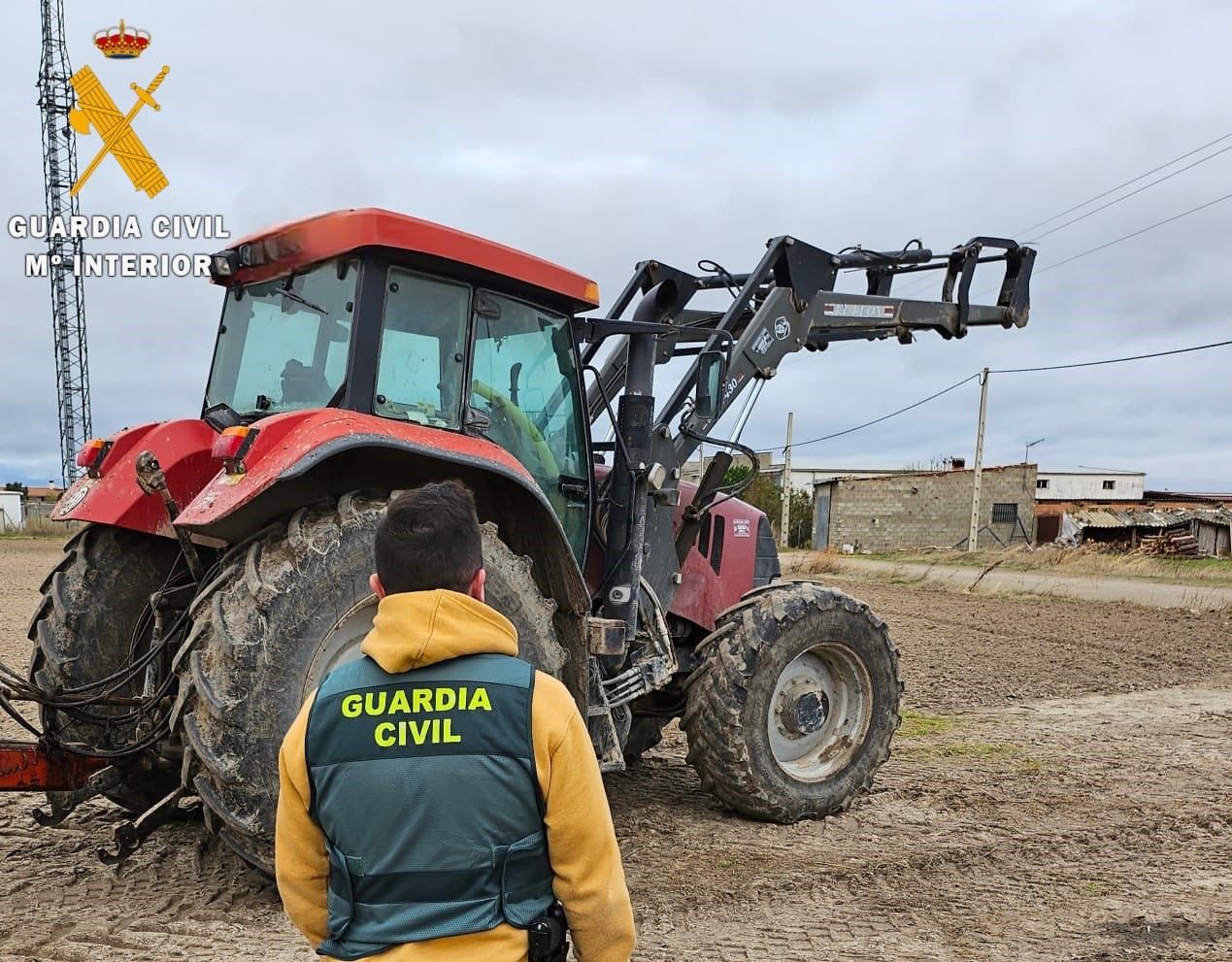 Agente de la Guardia Civil junto a uno de los tractores recuperados