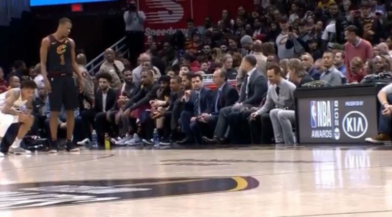 Kelly Oubre Jr, agachado y a punto de desatarle las zapatillas a Rodney Hood