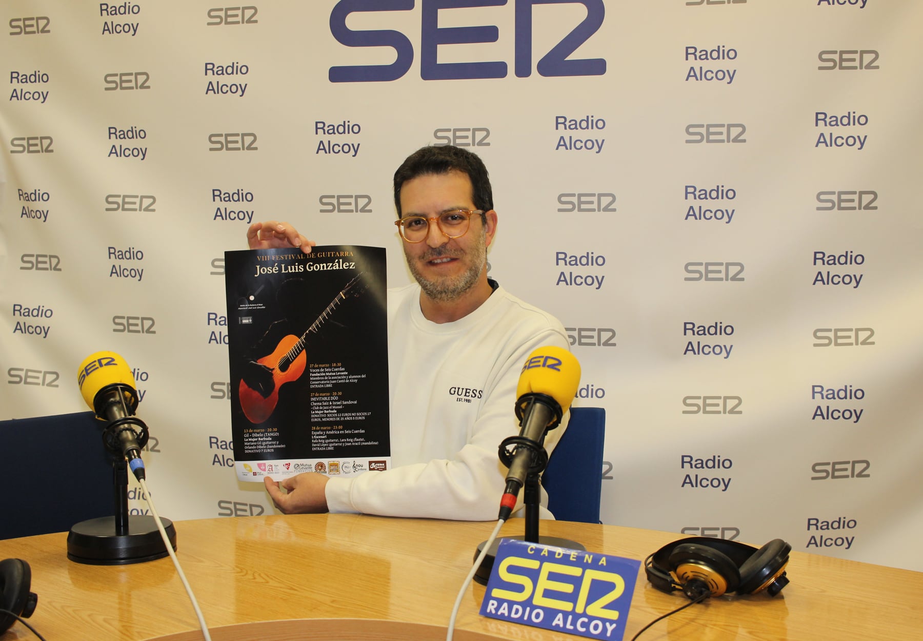 Joan Aracil, en el estudio central de Radio Alcoy, con un cartel de las actuaciones