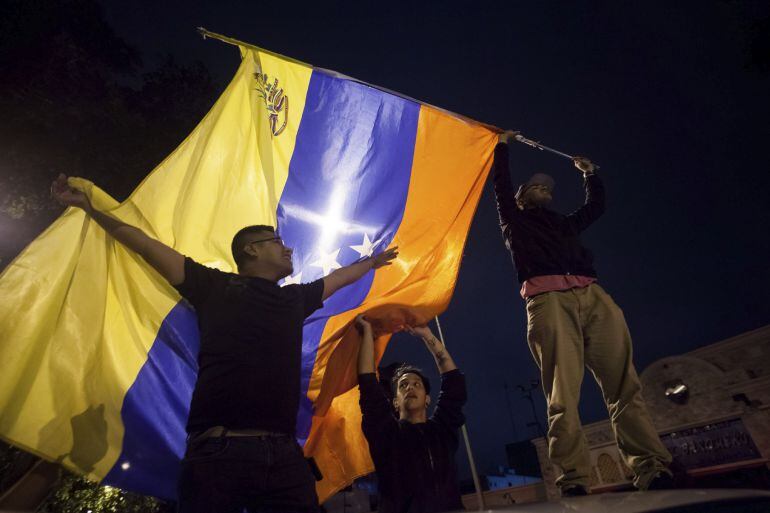 Un grupo de personas celebra la victoria obtenida por la coalición opositora Mesa de Unidad Democrática (MUD) 