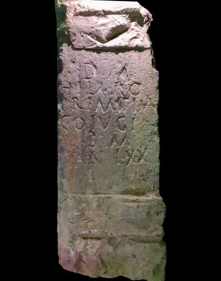 La lápida es de base calcárea y con remate moldurado.