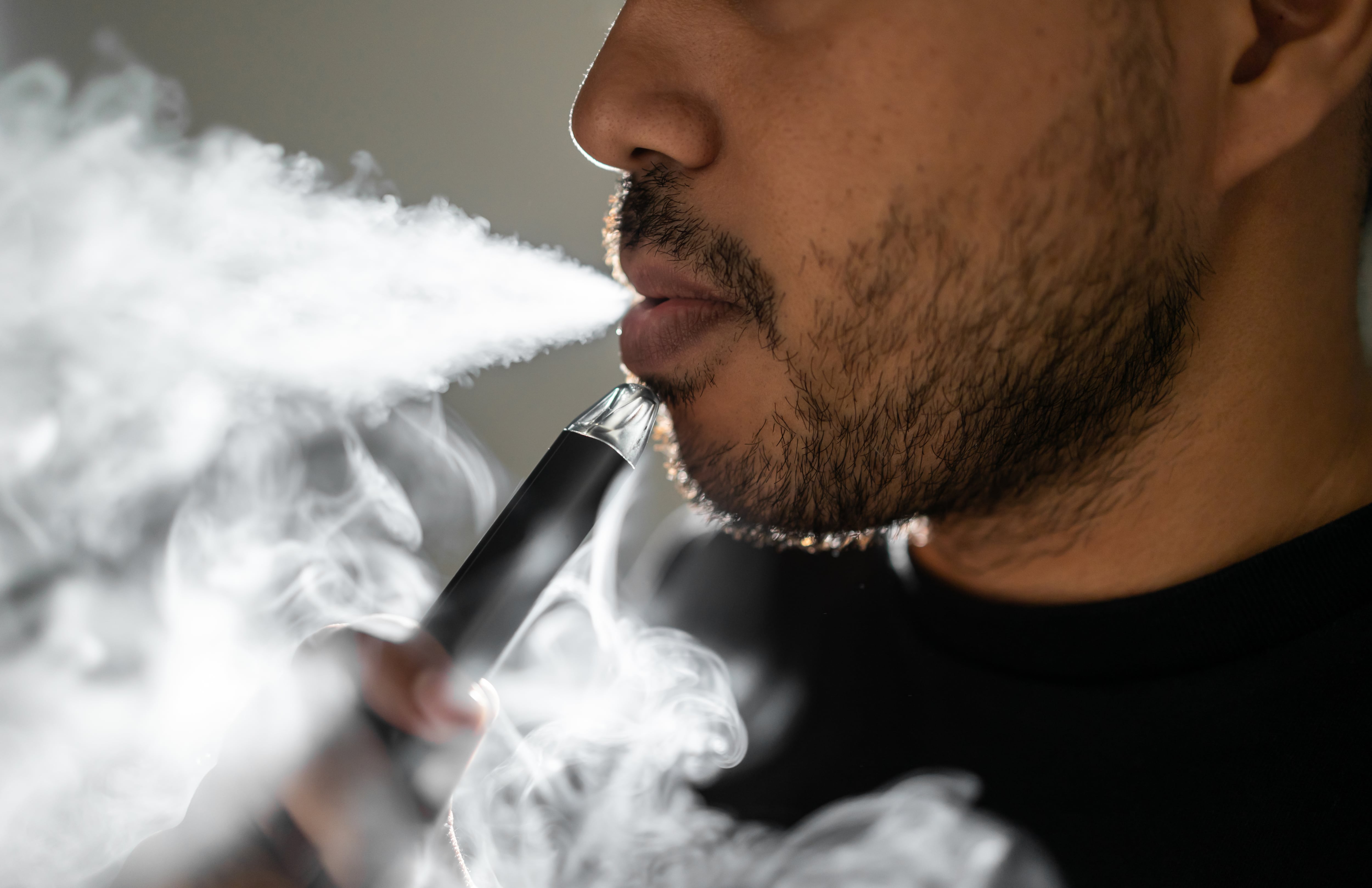 Close-up mouth of man smoke inhaling, breathing and smoke electronic cigarette.