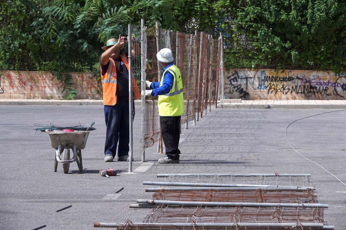 Trabajadores instalan un vallado en una imagen de archivo.