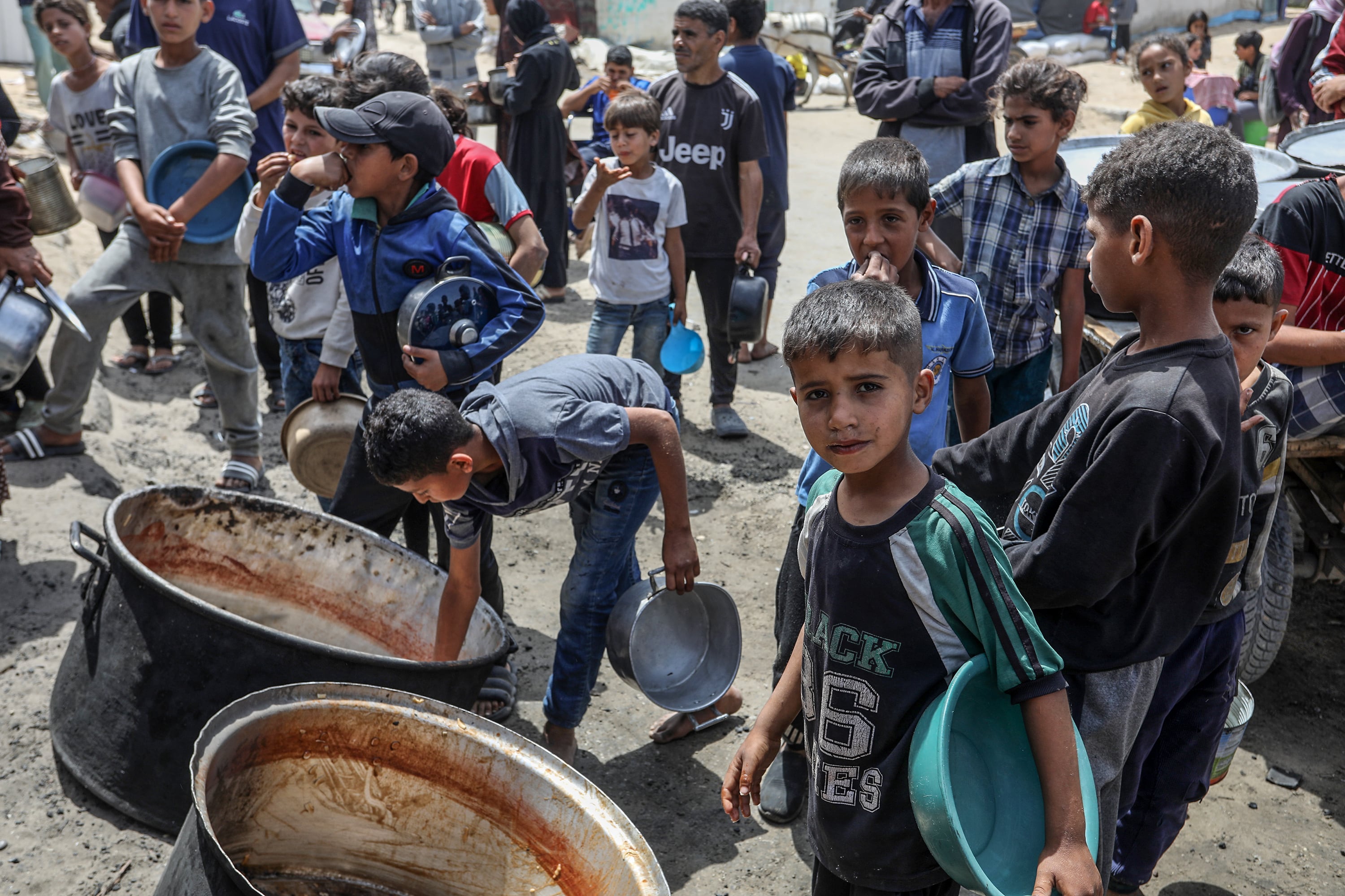 Un grupo de niños palestinos tratan de conseguir comida en Gaza. (Photo by Abed Rahim Khatib/Anadolu via Getty Images)