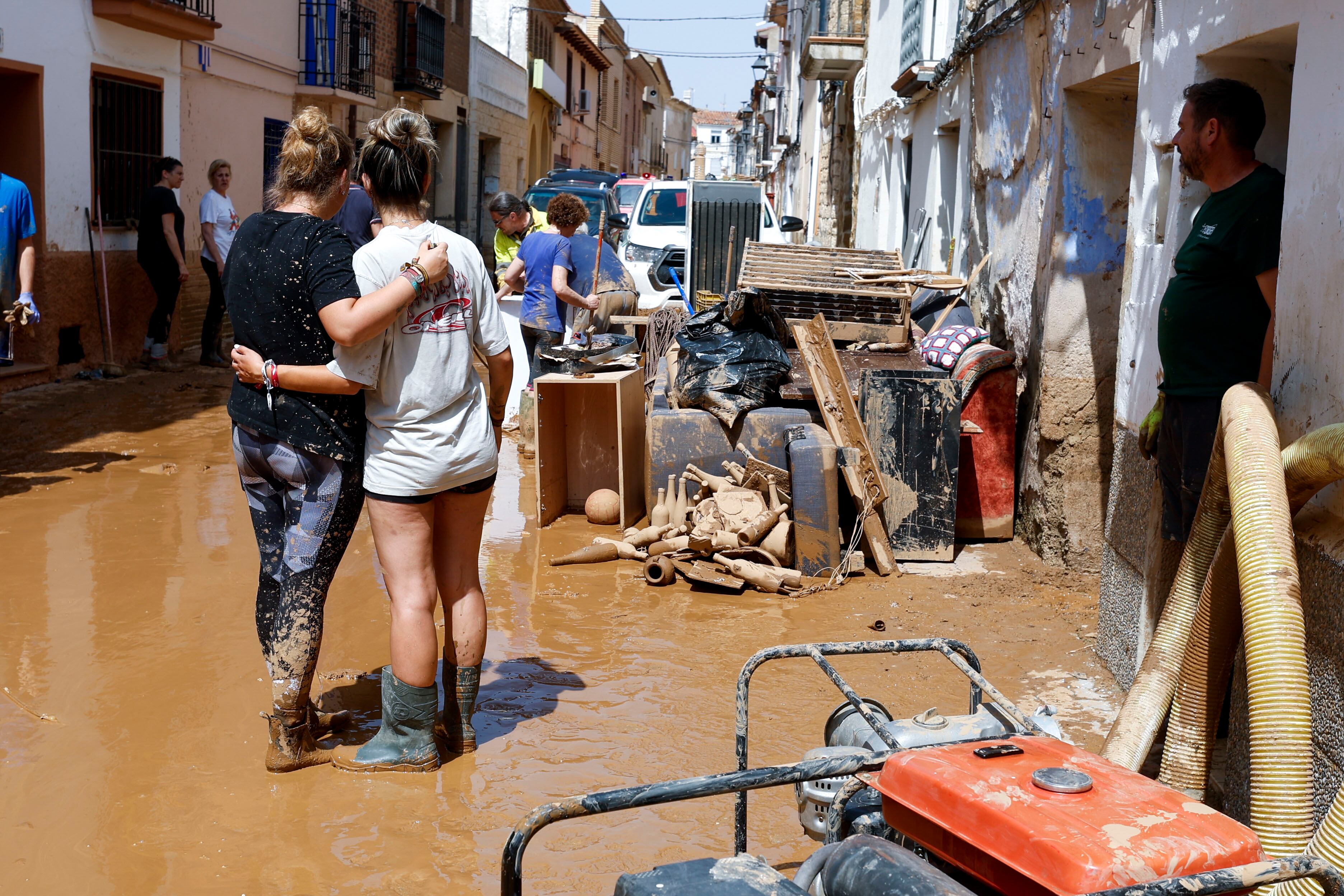 Vecinos de la localidad zaragozana de Letux achican barro y retiras mobiliario dañado este domingo.