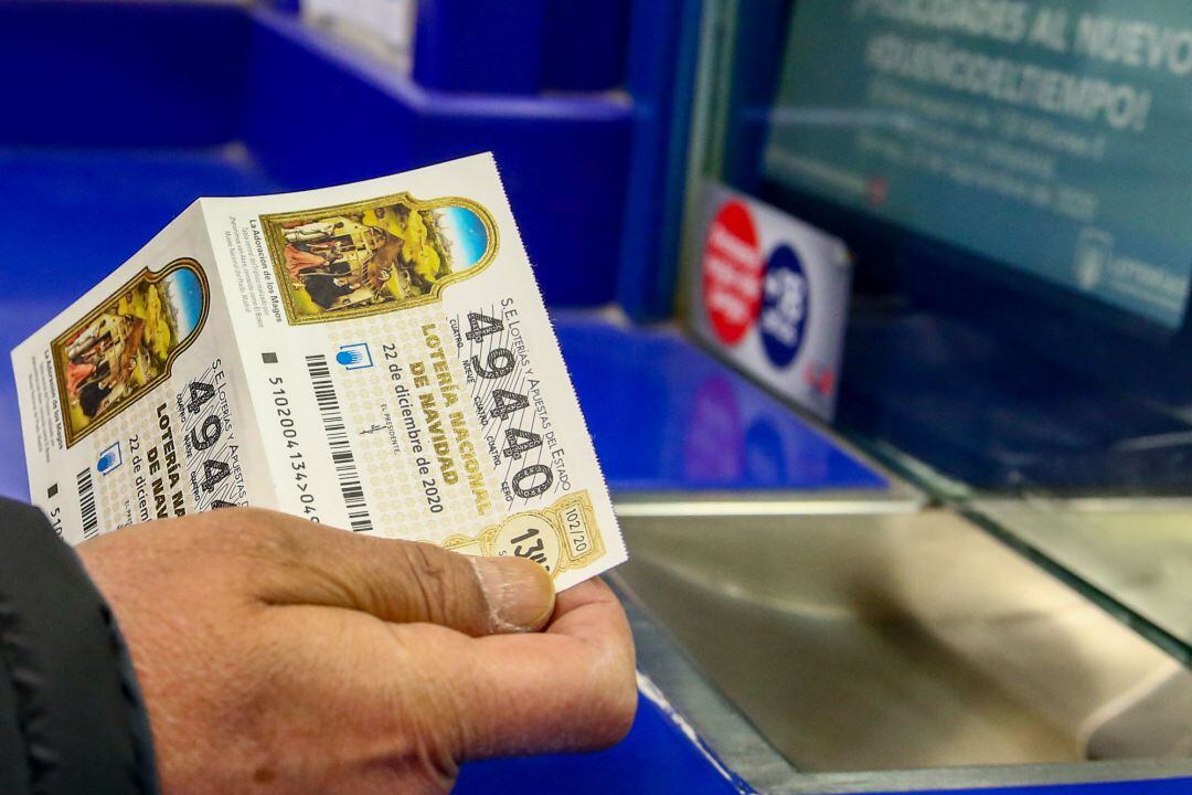 Una persona compra un décimo para el Sorteo Extraordinario de la Lotería de Navidad 