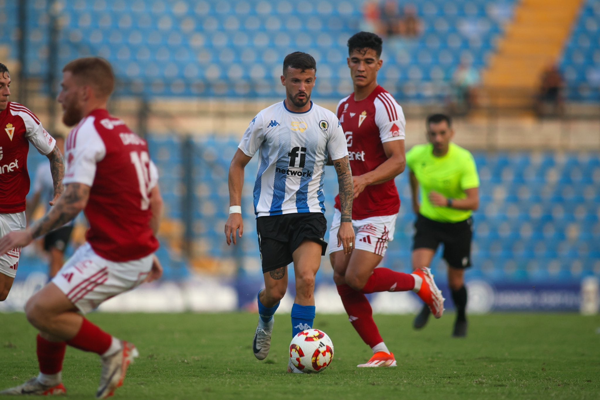 Javi Moreno conduce un balón ante la presión de los jugadores del Real Murcia. Foto: Hércules CF