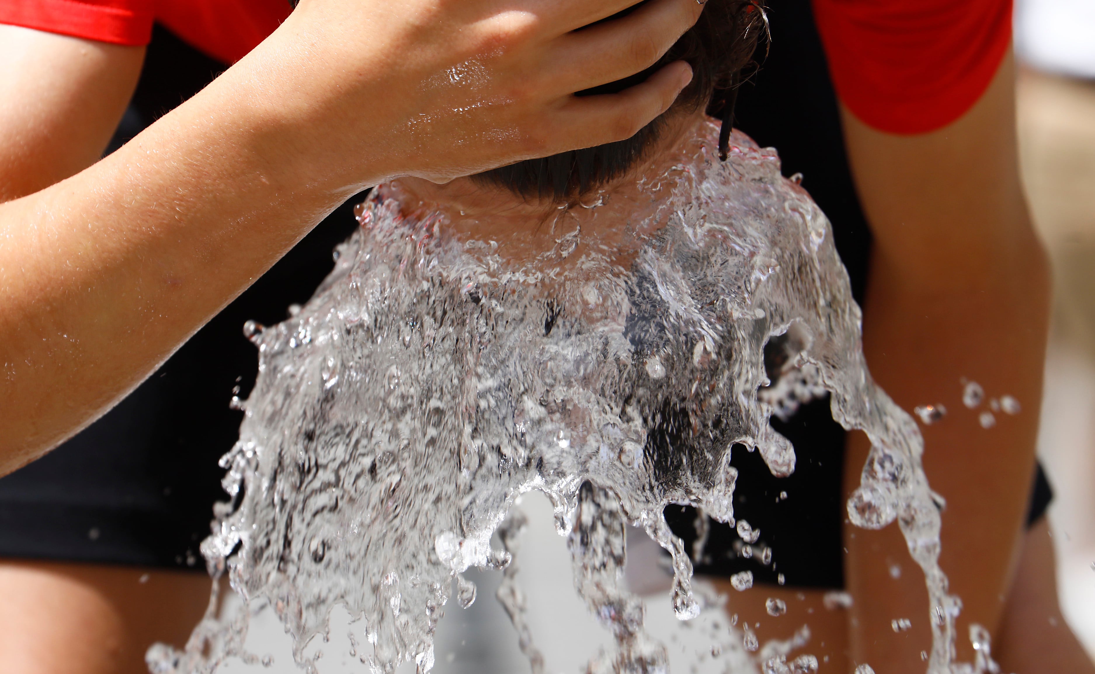 Un hombre se refresca en una fuente. EFE/Salas