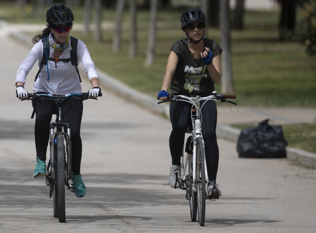 Dos mujeres circulan en bicicleta en el Parque del Manzanares.