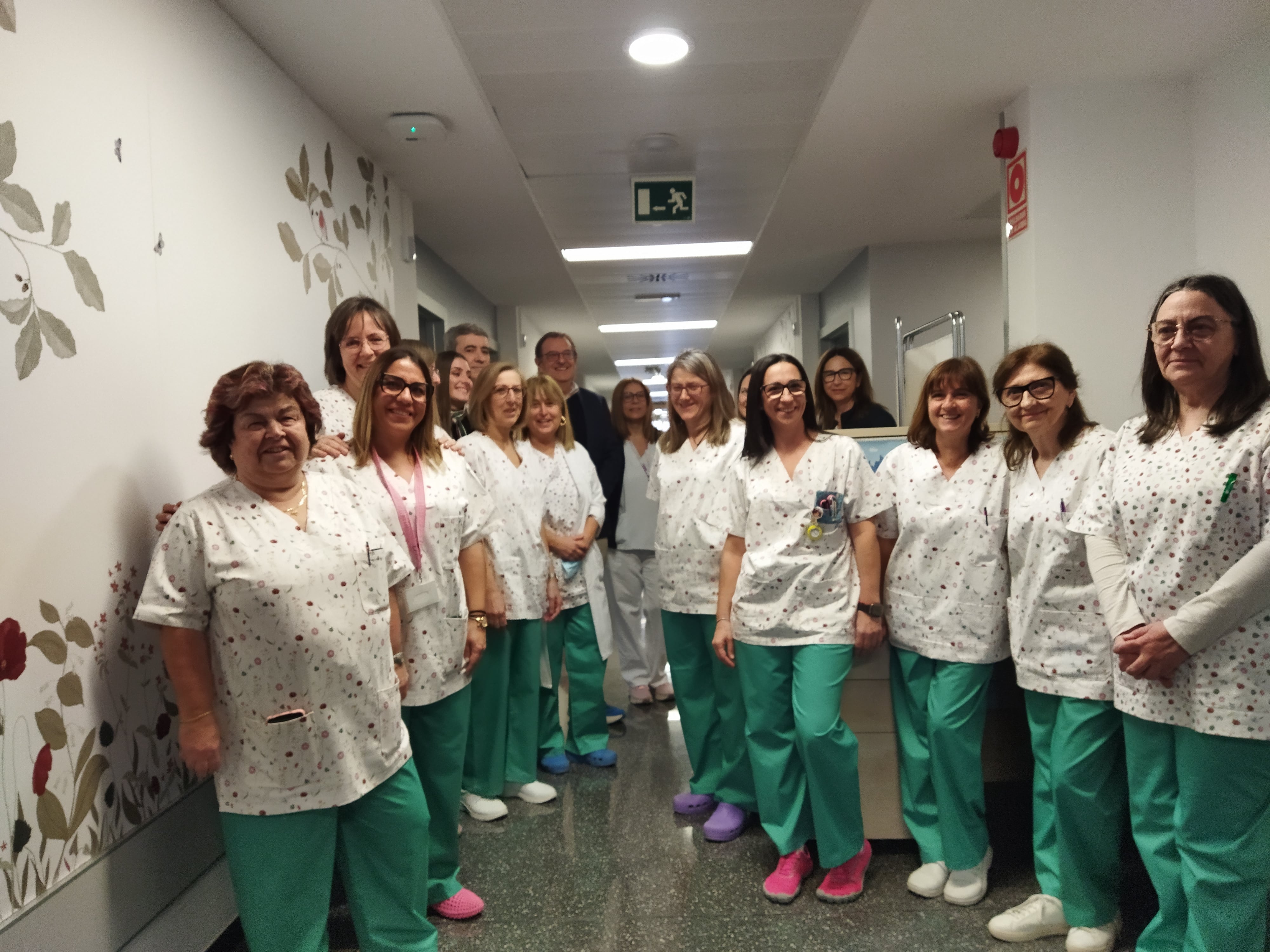 El personal sanitario, Alfredo Rizo, gerente del Departamento de Salud de Alcoy; Vicente Blanes, director general de Aitex; la diseñadora Inés Castelló y Bea Doménech, responsable del departamento de Institucional de Aitex, junto a uno de los murales que luce en el pasillo del hospital de día de oncología del Virgen de los Lirios de Alcoy.