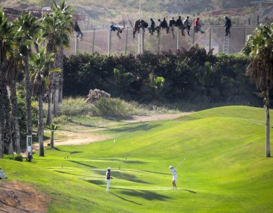 Al menos doce inmigrantes, encaramados en la valla de Melilla frente al campo de golf situado al lado de la alambrada que separa la ciudad autonoma de Marruecos