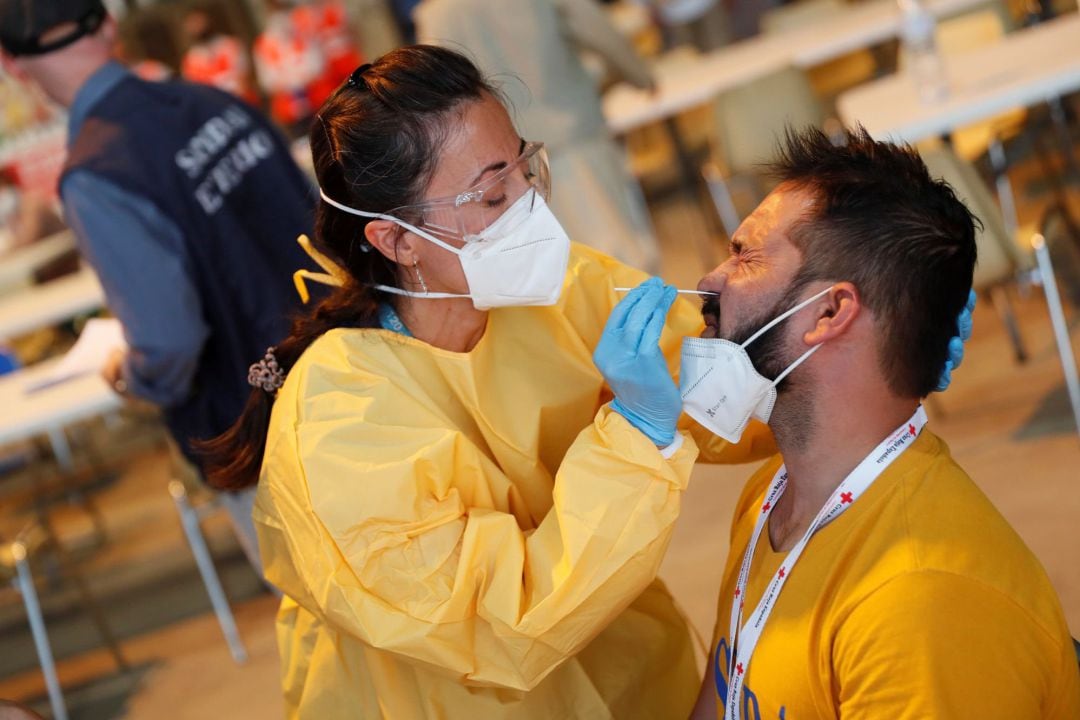  Personal sanitario somete a una prueba PCR a los llegados a la base aérea militar de Torrejón de Ardoz (Madrid)