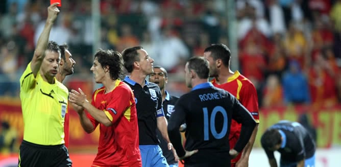 El árbitro central le muestra la tarjeta roja a Wayne Rooney (d) de Inglaterra hoy, viernes 7 de octubre de 2011, durante el juego clasificatorio de la Eurocopa 2012