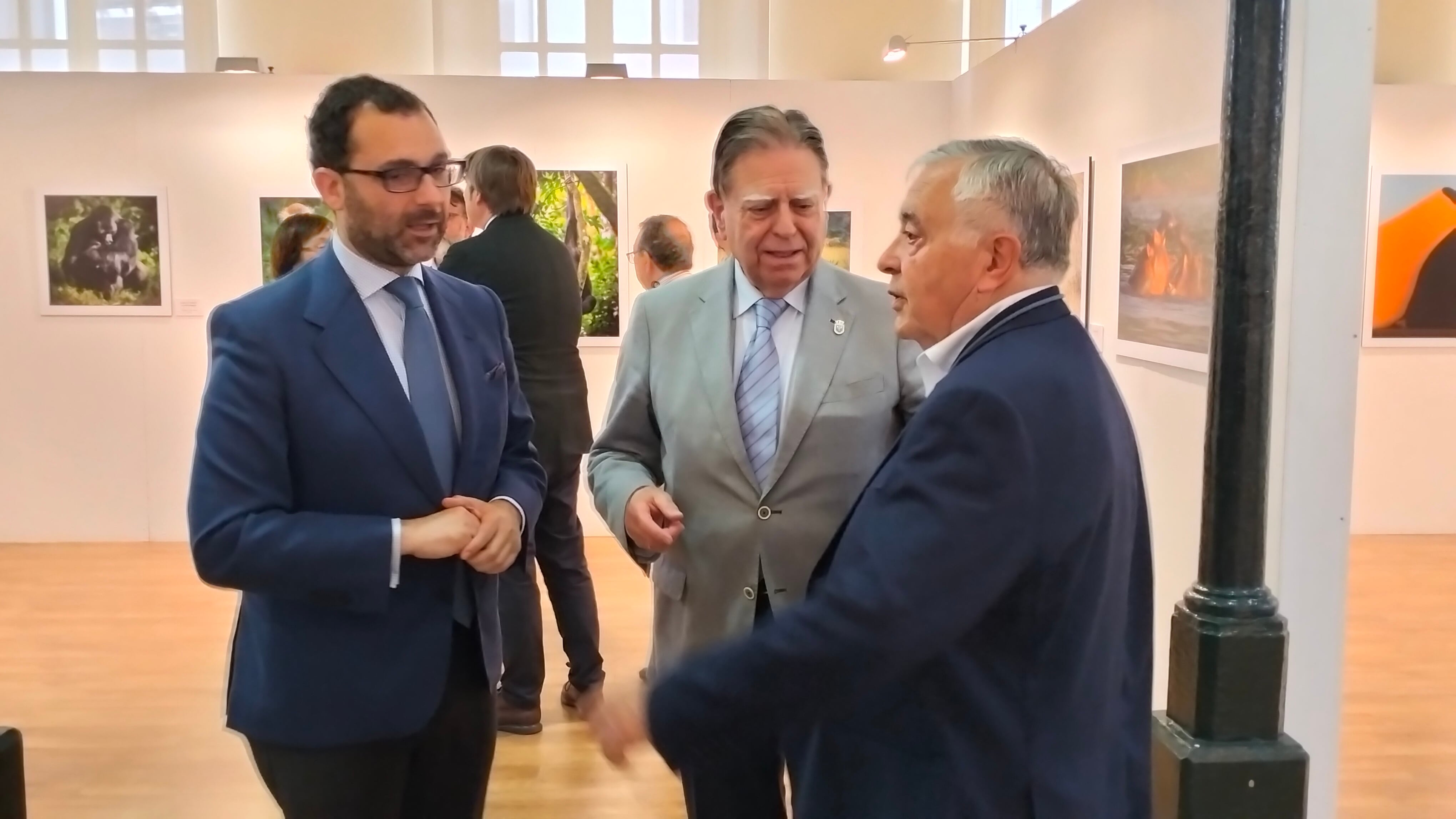 El concejal de Cultura, David Álvarez, y el alcalde de Oviedo, Alfredo Canteli, charlan con Emilio Cueto durante la inauguración de su exposición fotográfica en Trascorrales