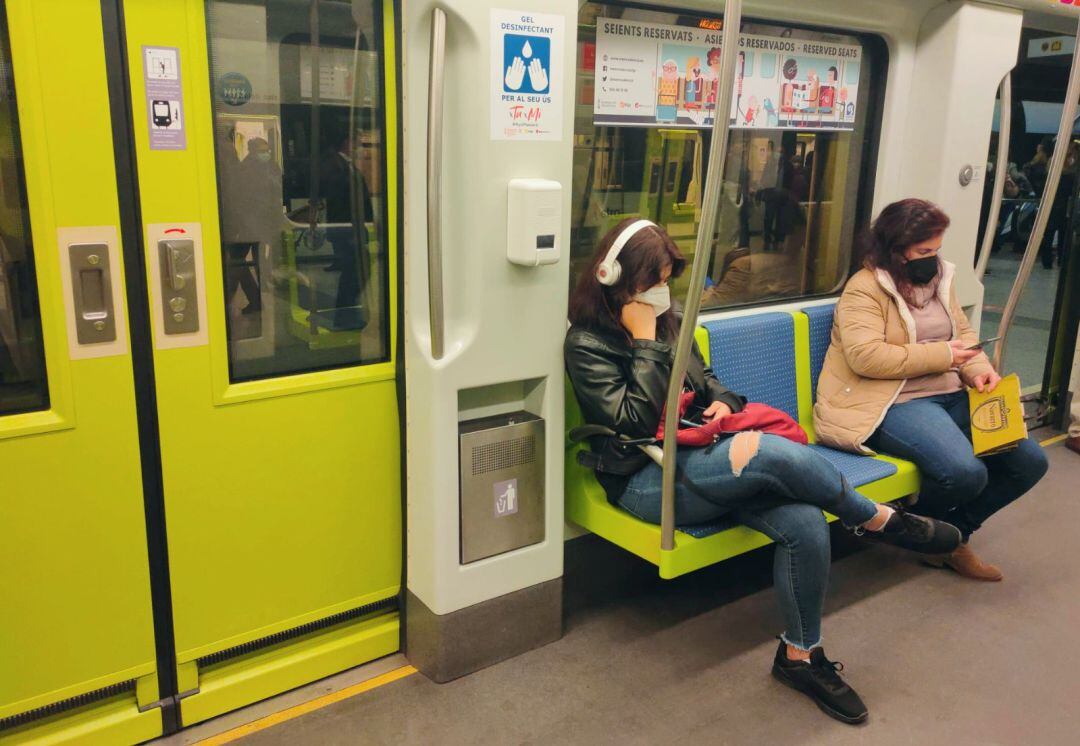 Dos usuarias de Metrovalencia escuchan música a través de sus auriculares