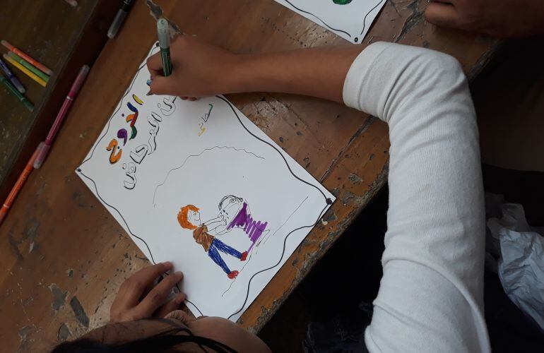 Una niña aprende buenos hábitos de salud mediante dibujos en la escuela de Al Tanak. 
 