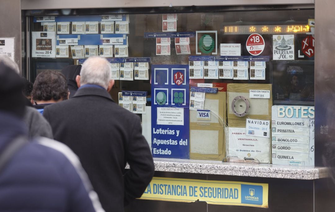 Varias personas en una administración de lotería de Navidad de la Puerta del Sol.